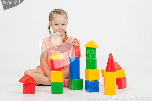 Image of Child cheerfully plays with blocks