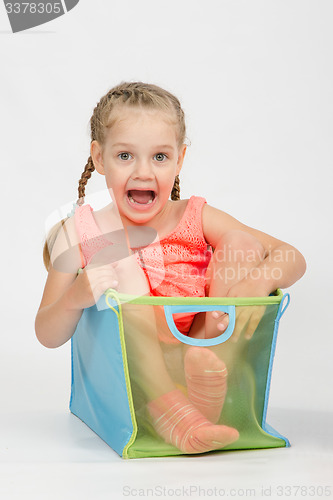 Image of Happy girl in a box for toys