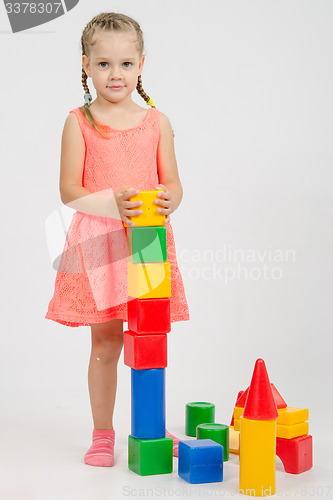 Image of Four-year girl builds a pyramid of cubes