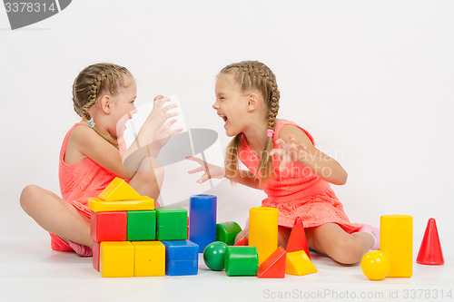 Image of Two girls frighten each other by playing with blocks