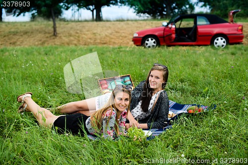Image of Best friends having a picnic next to their car