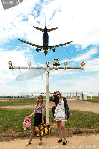 Image of Two girls hitchhiking a plane