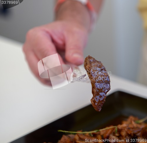 Image of dish of pork with sauce on black plate