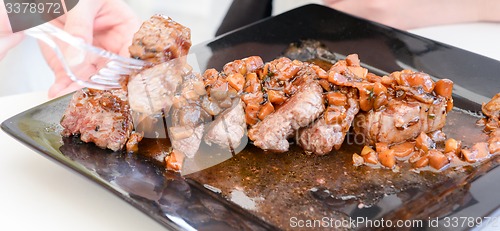 Image of dish of pork with sauce on black plate