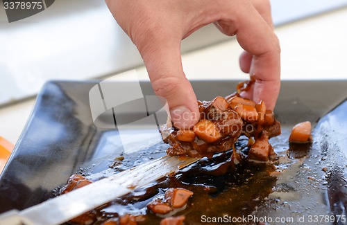 Image of dish of pork with sauce on black plate