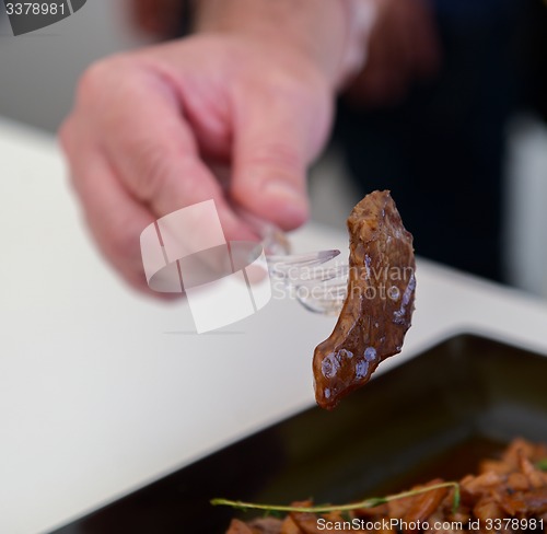 Image of dish of pork with sauce on black plate