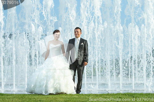 Image of Bride and groom in front of water fountain