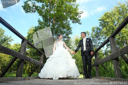 Image of Bride and groom holding hands