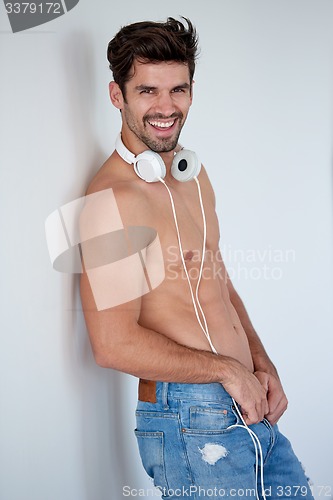 Image of handsome young man listening music on headphones