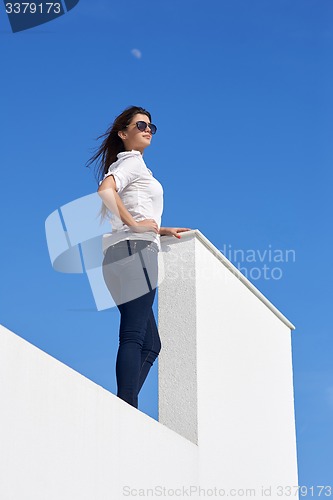Image of relaxed woman in front of luxury modern home