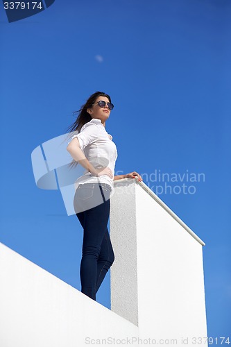 Image of relaxed woman in front of luxury modern home