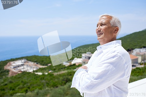 Image of senior man in front of modern home