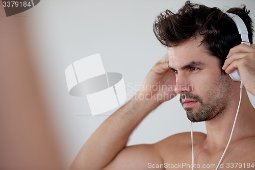 Image of handsome young man listening music on headphones