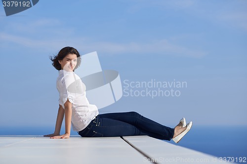Image of relaxed woman in front of luxury modern home