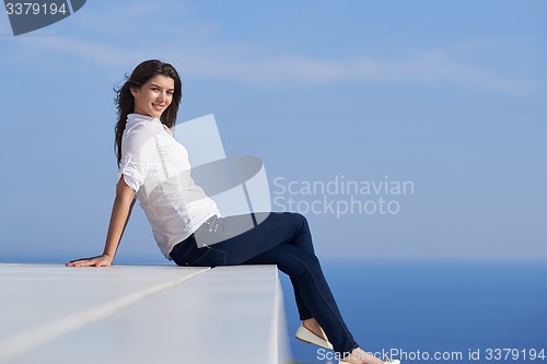 Image of relaxed woman in front of luxury modern home