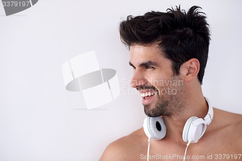 Image of handsome young man listening music on headphones