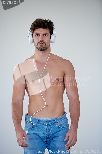 Image of handsome young man listening music on headphones