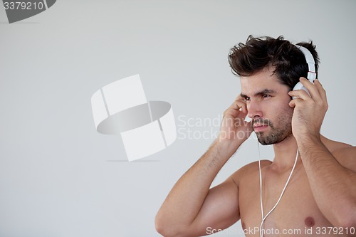 Image of handsome young man listening music on headphones