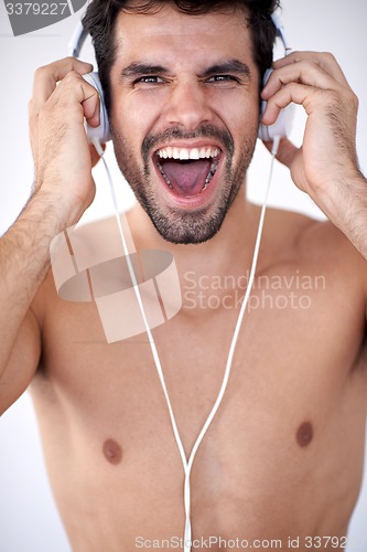 Image of handsome young man listening music on headphones