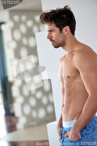 Image of shirtles handsome young man in jeans