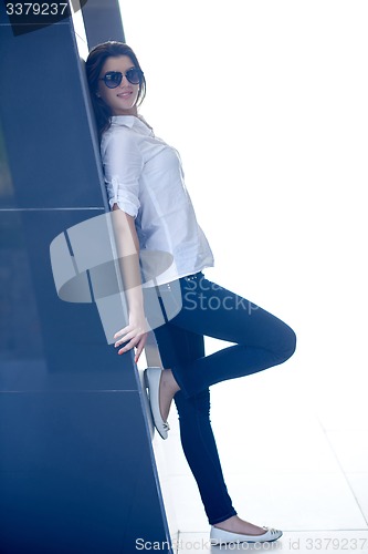 Image of relaxed woman in front of luxury modern home
