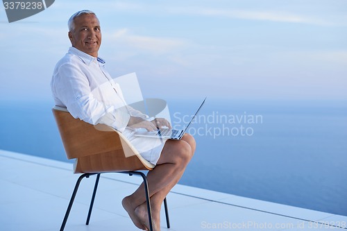 Image of senior man working on laptop computer