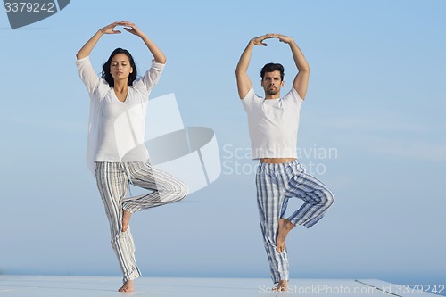 Image of young couple practicing yoga