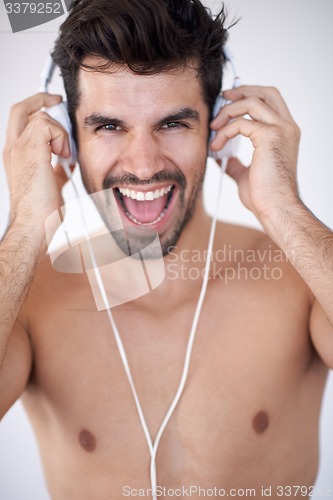 Image of handsome young man listening music on headphones