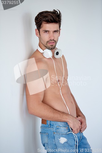 Image of handsome young man listening music on headphones