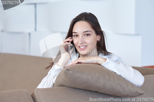 Image of young woman using cellphone at home