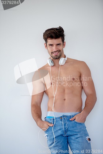 Image of handsome young man listening music on headphones