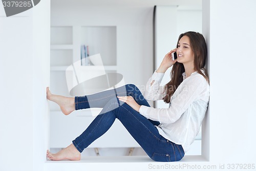 Image of young woman using cellphone at home