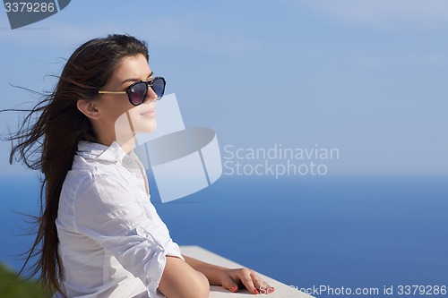 Image of relaxed woman in front of luxury modern home
