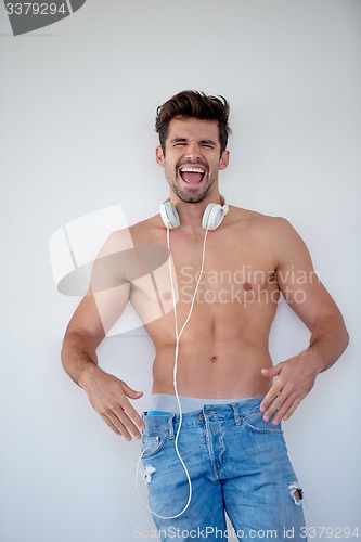 Image of handsome young man listening music on headphones