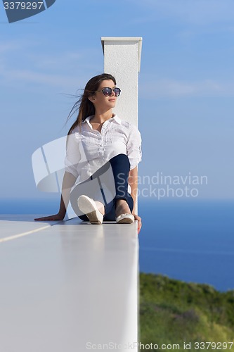 Image of relaxed woman in front of luxury modern home