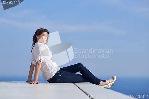 Image of relaxed woman in front of luxury modern home