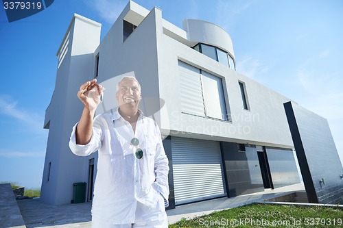 Image of senior man in front of modern home