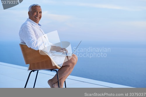 Image of senior man working on laptop computer