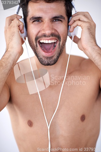 Image of handsome young man listening music on headphones