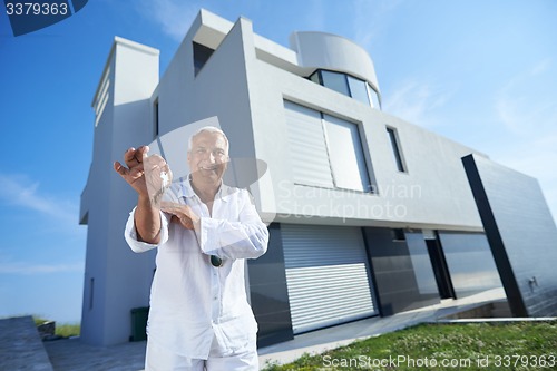 Image of senior man in front of modern home