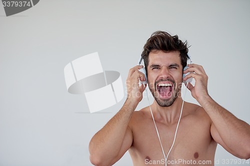 Image of handsome young man listening music on headphones