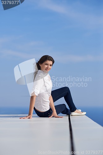 Image of relaxed woman in front of luxury modern home