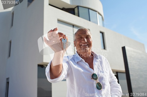 Image of senior man in front of modern home