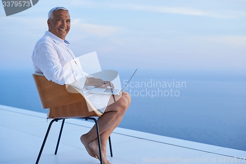 Image of senior man working on laptop computer