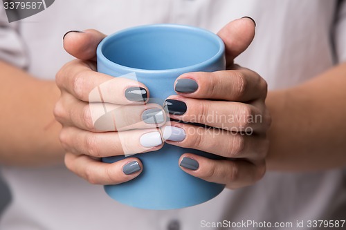 Image of Female hands with blue cup