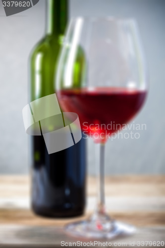 Image of red wine in goblet and green bottle