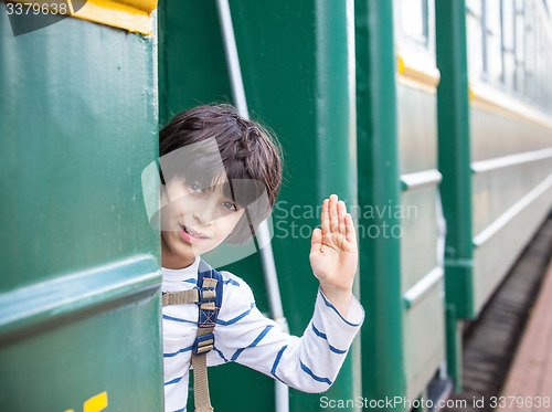 Image of boy waves his hand from railcar