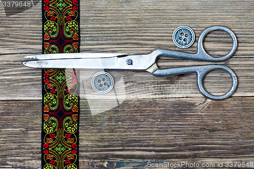 Image of antique embroidered tape, vintage buttons and a tailor scissors