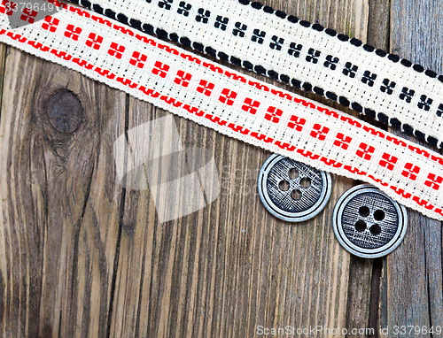 Image of two vintage ribbons with embroidered ornaments and old buttons