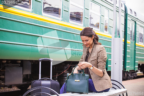 Image of beautiful woman rummages in a bag